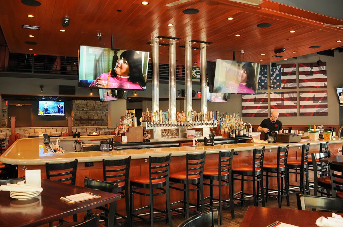 The shared bar area at Blackfinn, taps and screens along the wall.