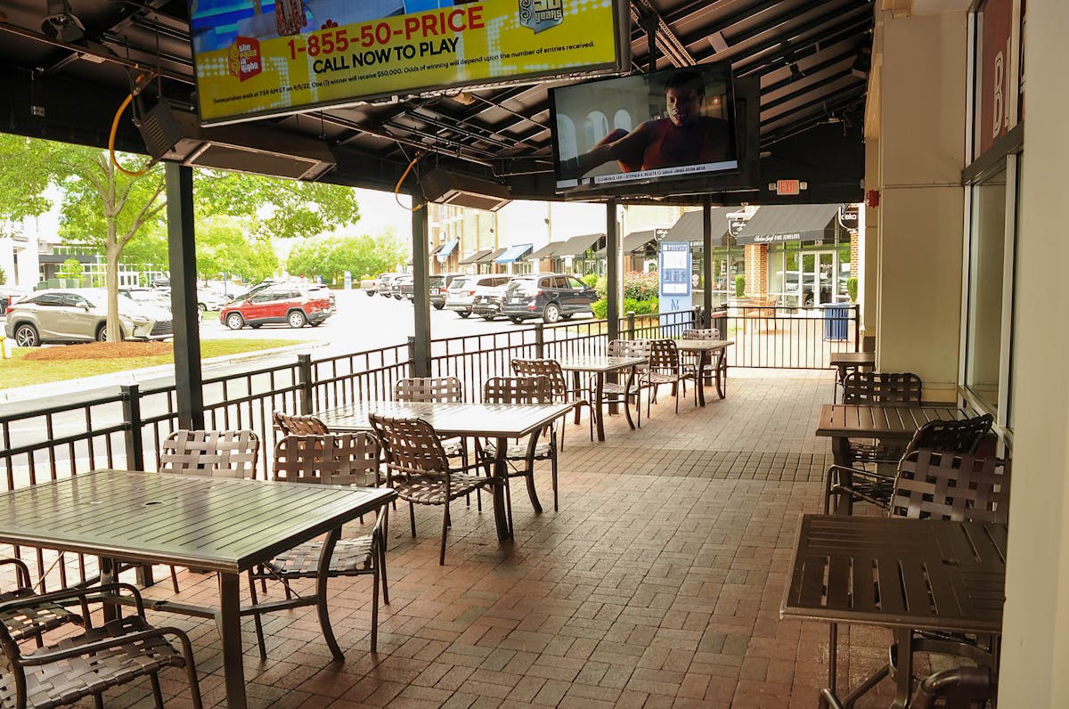 The patio at Blackfinn Ballantyne, outdoor tables outside the door.